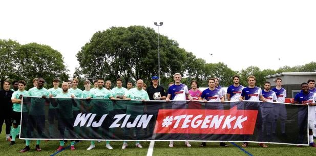 Sporters poseren met TegenKK spandoek