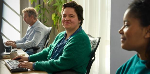 Collega's op kantoor achter de computer