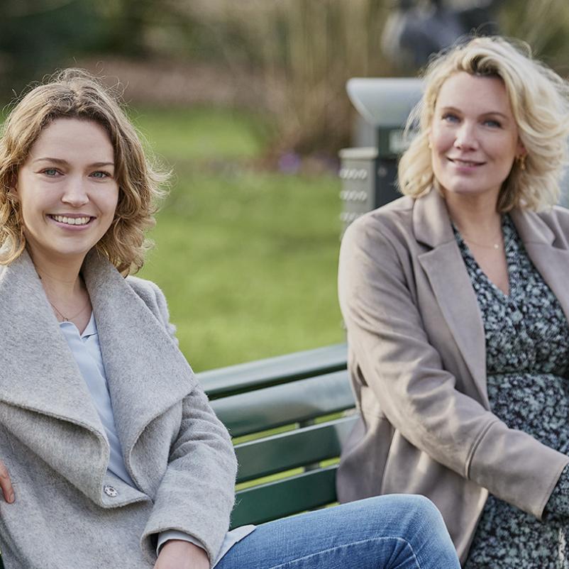 Twee vrouwen zitten op een bankje