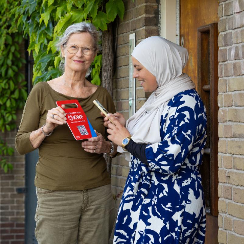 collectant aan deur met QR-bord KWF