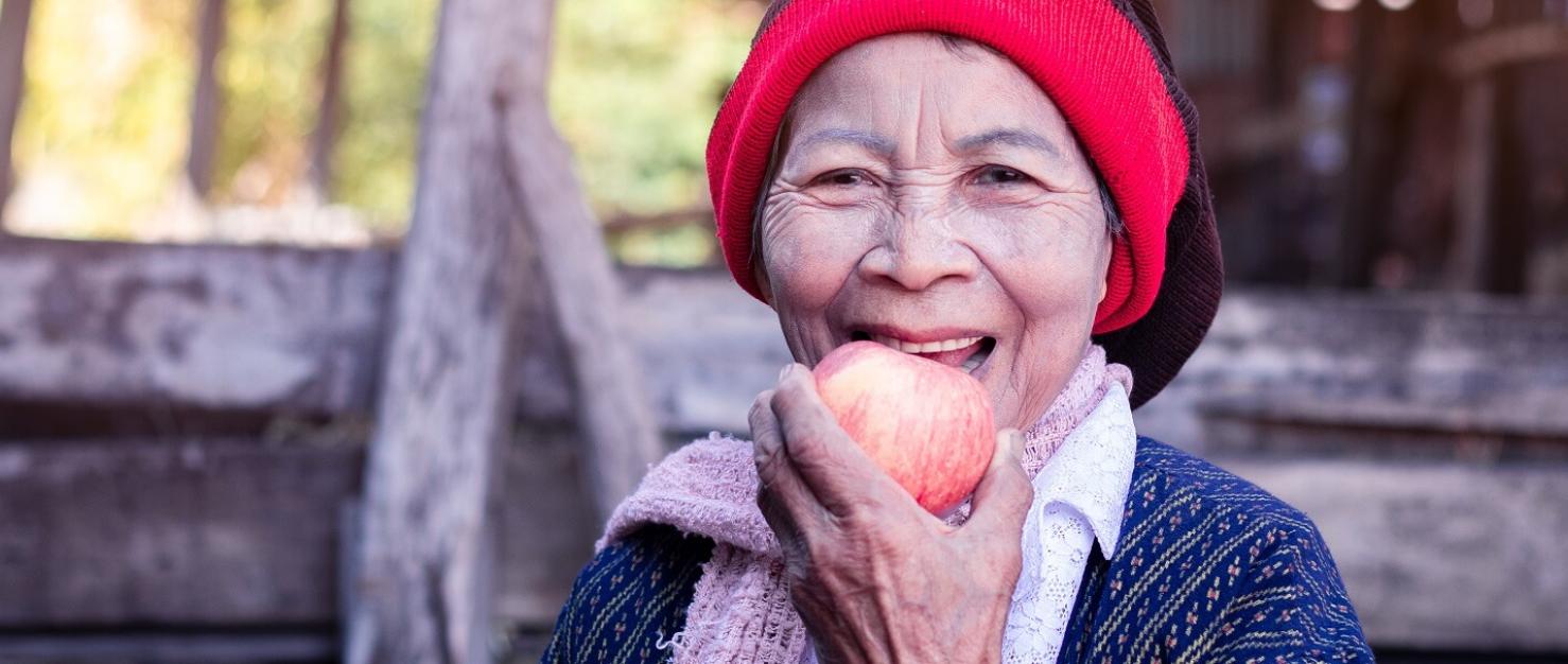 Oudere vrouw hapt in appel