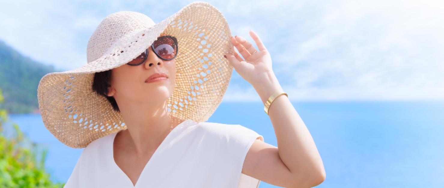 Vrouw met zonnebril en zonnehoed