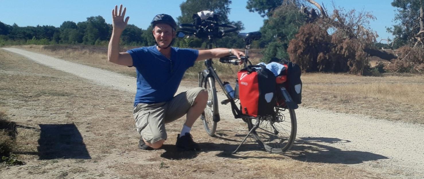 Man bij fiets op de hei