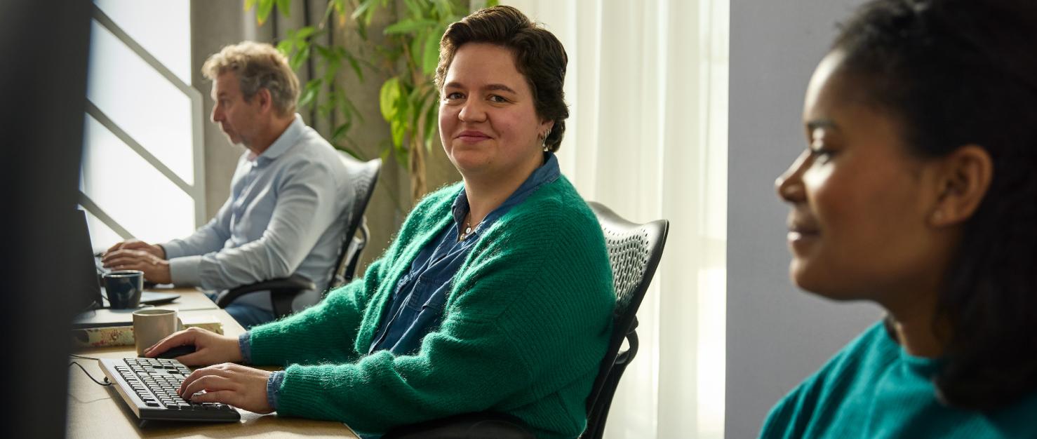 Collega's op kantoor achter de computer